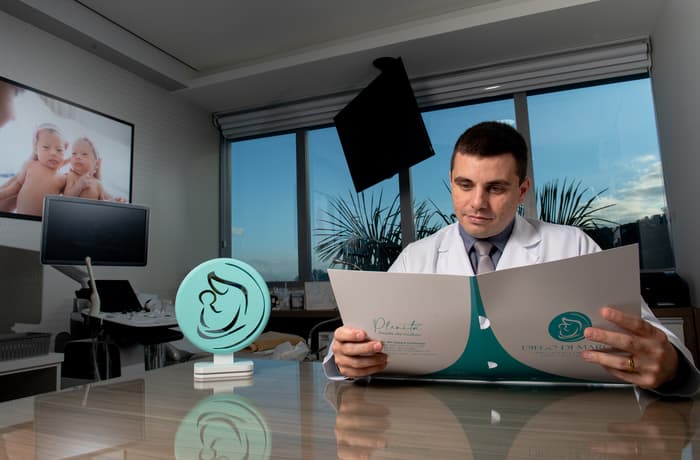 Retrato profissional do Dr. Diego Dimarco sorrindo em consultório.